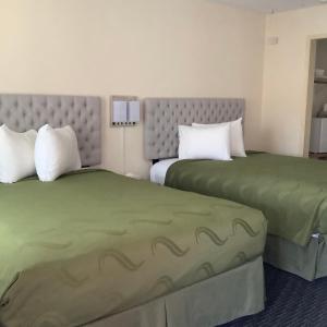 duas camas sentadas uma ao lado da outra num quarto de hotel em National 9 Motel em Santa Cruz