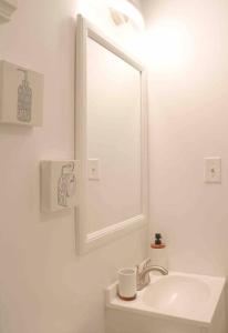 W białej łazience znajduje się umywalka i lustro. w obiekcie The New Luxury Cabin PetFriendly Pocono Summit w mieście Pocono Summit
