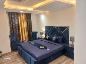 een slaapkamer met een blauw bed en 2 blauwe stoelen bij 2 bed Apartment in Gold crest apartment in Lahore