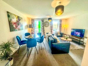 a living room with a couch and a table and chairs at Blueberry Tree Apartment in Cambridge