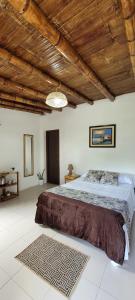 Palmendros Hosteria في مونتانيتا: غرفة نوم بسرير كبير وسقف خشبي