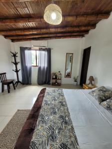 a bedroom with a large bed and a wooden ceiling at Palmendros Hosteria in Montañita