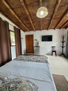 a large bedroom with two beds and a television at Palmendros Hosteria in Montañita