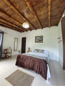 a bedroom with a bed and a wooden ceiling at Palmendros Hosteria in Montañita