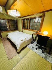 1 dormitorio con 1 cama, escritorio y ventanas en Nana House Ekoda - Private House, en Tokio