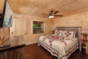 een slaapkamer met een bed en een plafondventilator bij Heavenly Daze in Sevierville