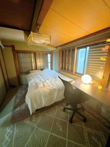 1 dormitorio con 1 cama y escritorio con escritorio en Nana House Ekoda - Private House, en Tokio
