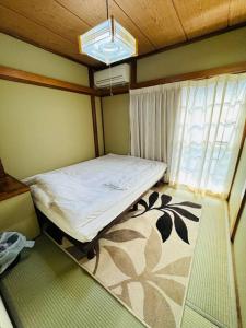 Habitación pequeña con cama y ventana en Nana House Ekoda - Private House, en Tokio