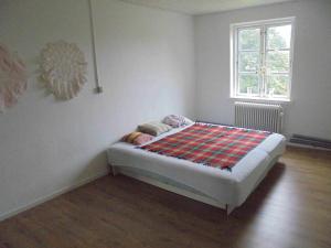 uma pequena cama num quarto com uma janela em Christianslund em Randers