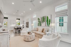 a white living room with a couch and a table at Beach Village Resort By Liquid Life in Gulf Shores
