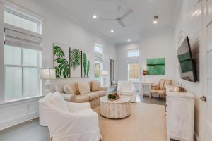 a living room with white furniture and a table at Beach Village Resort By Liquid Life in Gulf Shores