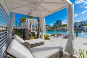 a patio with white chairs and a white umbrella at Beach Village Resort By Liquid Life in Gulf Shores