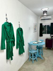 um casaco verde pendurado numa parede ao lado de uma mesa em Suíte Capixaba - 06 em Gravatá