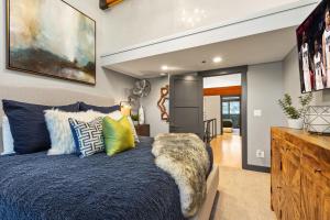 a bedroom with a blue bed with colorful pillows at Enjoy a Modern Luxury Design, Central Location, Hot Tub & Recreation! Deer Valley Fawngrove 1674 in Park City