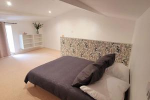 1 dormitorio con 1 cama con cabecero acolchado en Maison Esprit Nature - Puy du Fou, en Saint-Laurent-sur-Sèvre