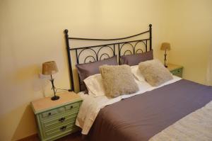 a bedroom with a bed with two lamps and a nightstand at Ojaranzo in Candeleda