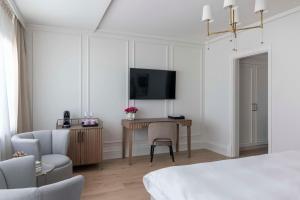 una camera da letto con scrivania, TV e sedia di Grand Hotel Oslo a Oslo