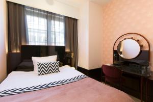 Pokój hotelowy z łóżkiem i lustrem w obiekcie Haymarket by Scandic w Sztokholmie