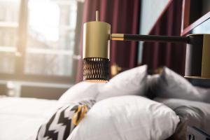 a candle sitting on top of a bed with pillows at Haymarket by Scandic in Stockholm
