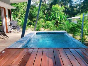 a swimming pool on a deck with a wooden floor at Villa Akala in Cocles