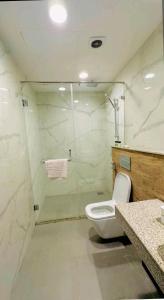 a white bathroom with a toilet and a shower at Premium&Cozy Studio DHA Lahore in Lahore