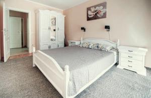 - une chambre blanche avec un lit blanc et une commode dans l'établissement Apartments Marina, à Rafailovici