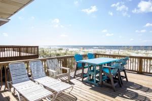 uma mesa e cadeiras num deque com praia em Gulf Front Beach House Sleeps 12 em Gulf Shores