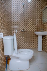 a bathroom with a toilet and a sink at Gmasters Homes kibagabaga in Kigali