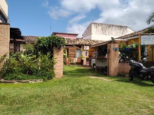 ein Haus mit einem Motorrad auf dem Hof in der Unterkunft Suíte privativa acesso rápido 5 minuto balsa in Ilhabela