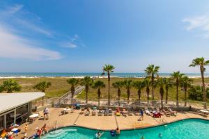 un grupo de personas sentadas alrededor de una piscina en la playa en Gulf Front Condo Outdoor & Indoor Pools 106, en Orange Beach