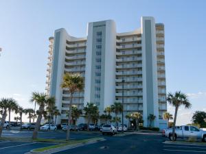 un gran edificio blanco con palmeras en un aparcamiento en Gulf Front Condo Outdoor & Indoor Pools 106, en Orange Beach