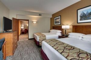 シャーロットにあるDrury Inn & Suites Charlotte Northlakeのベッド2台、薄型テレビが備わるホテルルームです。