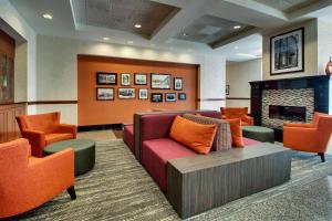 a waiting room with a couch and a fireplace at Drury Inn & Suites Findlay in Findlay