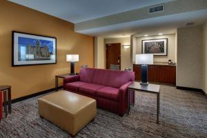 a living room with a red couch and a chair at Drury Inn & Suites Findlay in Findlay