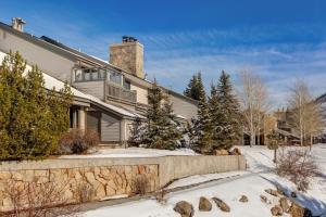 a house with snow on the ground in front of it at Enjoy a Modern Luxury Design, Central Location, Hot Tub & Recreation! Deer Valley Fawngrove Estate in Park City