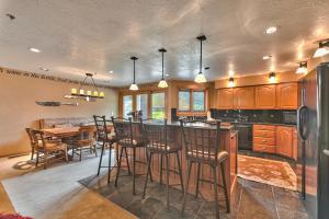 a kitchen with a bar and a table with chairs at Great Location, Hot Tub & Outdoor Recreation! Deer Valley Fawngrove Terrace in Park City