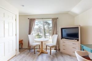 Una sala de estar con una mesa y un televisor. en Seal Three Condo Getaway, en Lincoln City