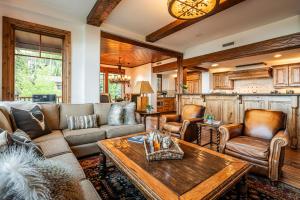 a living room with a couch and a table at Luxury Amenities & Year-Round Recreation at Deer Valley Grand Lodge 307! in Park City