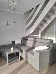 a living room with a couch and a staircase at Villetta Rewal in Rewal