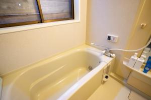 a white bath tub in a bathroom with a window at Minsyuku Mirai - Vacation STAY 94810v in Tokamachi