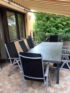 une table et des chaises assises sur une terrasse dans l'établissement Holiday home in Balatonboglar 49936, à Balatonboglár