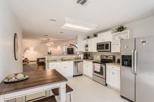 a kitchen with white cabinets and a wooden table at Hidden Gem near F1! 3bd/2bath - Private Backyard! in Austin