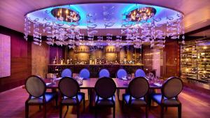 une salle à manger avec une table, des chaises et un bar dans l'établissement Palacio Mundo Imperial Riviera Diamante Acapulco All Inclusive, à Acapulco