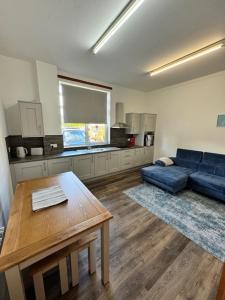 a living room with a blue couch and a table at Ben Lomond Apartment in Alexandria