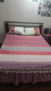 a bed with a quilt and pillows on it at 3 NOCHES MINIMAS ESTACIA-HABITACION APARTAMENTO COMPARTIDO-VENTILADOR NO aire acondicionado in Valledupar