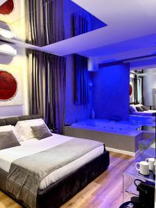 a blue bedroom with a bed and a tub at Four Luxury Suite in Palermo
