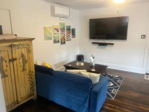 a living room with a blue couch and a table at The Bait & Tackle - Newly renovated suite apt 2 in Bryson City