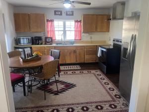 a kitchen with a table with chairs and a refrigerator at The Bait & Tackle - Newly renovated suite apt 2 in Bryson City