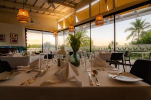 un comedor con una mesa con manteles blancos y cubiertos en Oceana Resort & Conventions, en Monterrico
