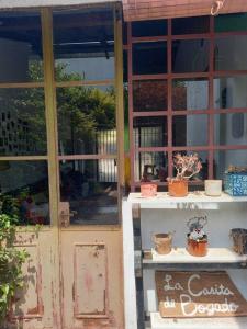 uma porta aberta de uma casa com vasos de plantas em La Casita de Bogado em Boulogne